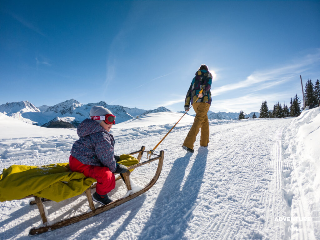 Wandern mit Kleinkind auf dem Schlitten in Arosa