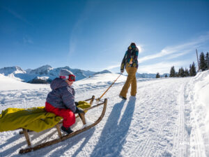 Wandern mit Kleinkind auf dem Schlitten in Arosa